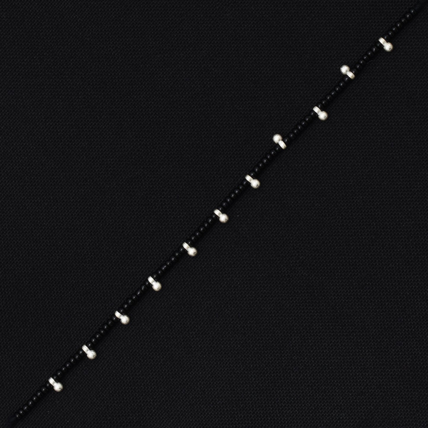 Charming dhaga bracelet with silver and black beads, offering a perfect balance of elegance and style