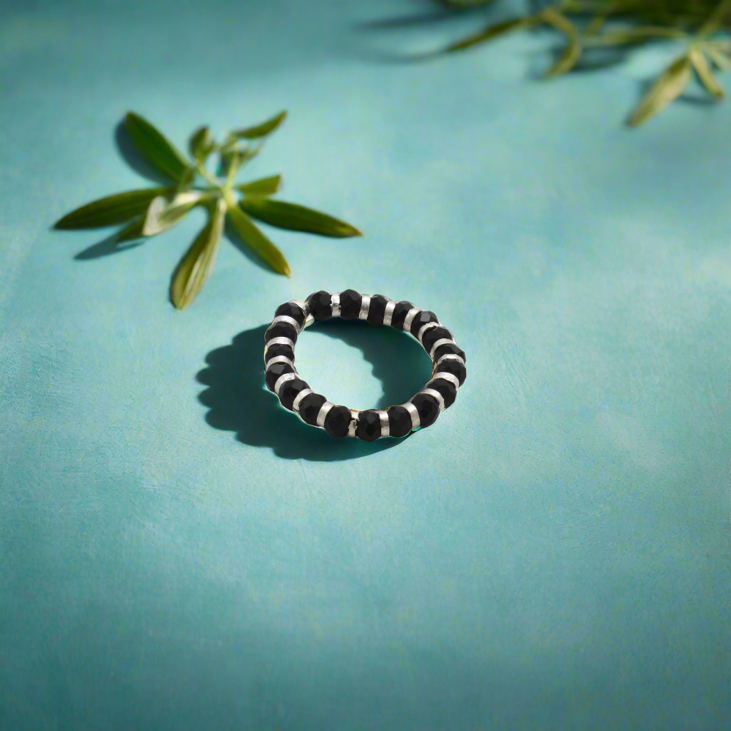 Elegant silver ring showcasing a chain of black beads, combining sophistication and contemporary style